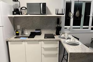 a kitchen with a counter top with a microwave at Vista Para o Mar no 8º Andar conforto e Charme 807 in Salvador +6 photos