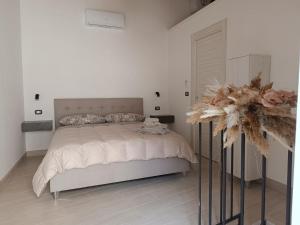 a white bedroom with a bed and a vase with flowers at Casa Vacanze Ngopp u Titl in Roseto Valfortore