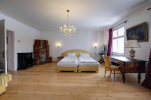 a bedroom with a bed and a desk and a chandelier at Florian's Haus in Cisnădioara