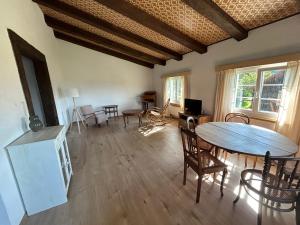 a living room with a table and chairs and a dining room at Appartement dans joli village de campagne in Col des Rangiers +2 photos