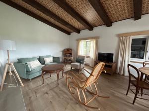 a living room with a couch and a table and chairs at Appartement dans joli village de campagne in Col des Rangiers