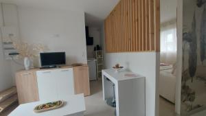 a kitchen with a refrigerator and a table with a television at Chez Marie in Vannes
