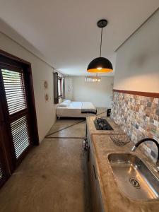 eine Küche mit Spüle und ein Bett in einem Zimmer in der Unterkunft Casa perfeita para 10 com piscina, beachtennis e churrasqueira in Barra Grande