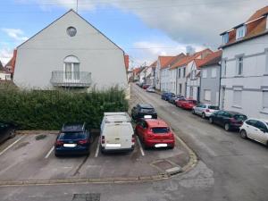 a group of cars parked in a parking lot at Maison de pêcheur la CORBOE in Étaples