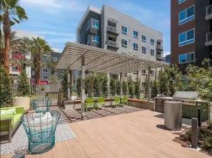 a patio with chairs and an umbrella and a building at Spacious 2 Bedroom Apartment Near Disneyland and Anaheim Convention Center in Anaheim