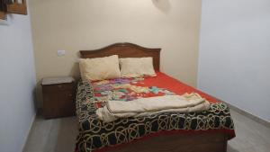 Un dormitorio con una cama con una manta encima. en Country house, en Al Aqālitah