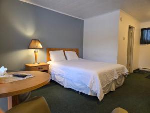 a hotel room with a bed and a table at Valois Motel & Restaurant in Mattawa