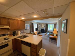 a kitchen with a sink and a living room at Pico Village Resort D209 in Killington