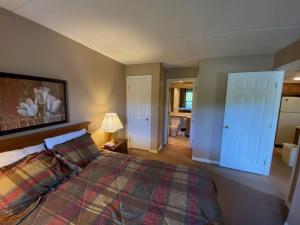 a bedroom with a king sized bed and a bathroom at Pico Village Resort D209 in Killington