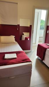 圣保罗Morada City Hostel的有两张床和一面红墙的卧室