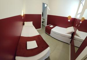 圣保罗Morada City Hostel的红色和白色墙壁的客房内的两张床