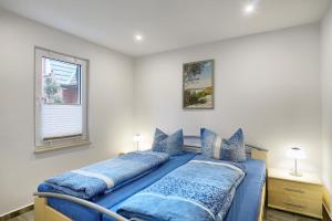 een slaapkamer met een bed met blauwe kussens bij Haus Havelland in Zingst