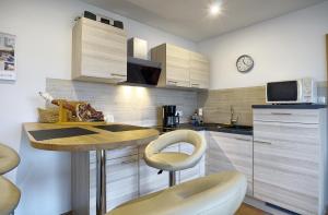 een keuken met een tafel, stoelen en een magnetron bij Haus Havelland in Zingst