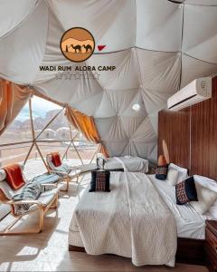 1 camera da letto in una tenda con letto e sedie di WADI RUM ALORA lUXURY CAMP a Wadi Rum