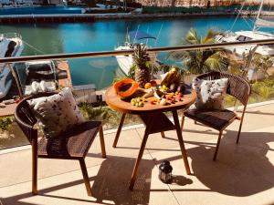 a table and two chairs with fruit on a balcony at Marina Corazón Sea View - Condo Puerto Cancún in Cancún