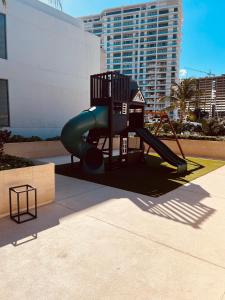 a playground with a slide in front of a building at Marina Condos Corazón 201 in Cancún