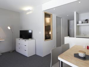 Jest to biały pokój ze stołem i telewizorem. w obiekcie Studio cabine rénové pour 5 pers. avec balcon, au calme, proche Transarc et commerces, Wifi inclus - FR-1-346-355 w mieście Arc 1800