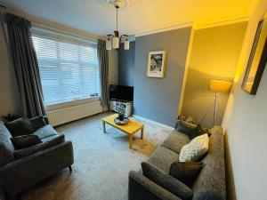 ein Wohnzimmer mit Sofa und Tisch in der Unterkunft Delightful 3 bedroom Cottage in Haverigg in Haverigg