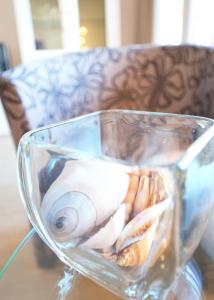 een glazen vaas gevuld met schelpen op een tafel bij STRANDIDYLL, 12 - Typ A2S in Grömitz