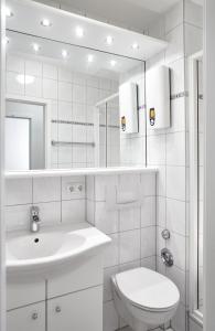 een witte badkamer met een wastafel en een toilet bij STRANDIDYLL, 12 - Typ A2S in Grömitz +12 foto's