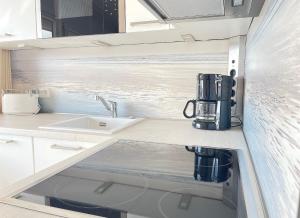 een keuken met een wastafel en een koffiezetapparaat op een aanrecht bij STRANDIDYLL, 23 - Typ A1S in Grömitz +16 foto's
