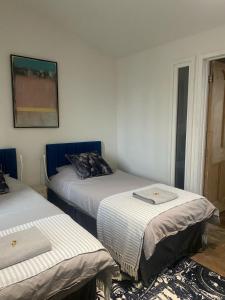 a room with two beds and a picture on the wall at Norfolk Chapel hideaway in Briston