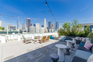 a rooftop patio with furniture and a view of the city at Stunning 3 Bedroom High-Rise with Pool, Spa, and Rooftop Views in Los Angeles