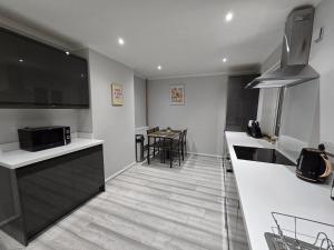 a kitchen with white countertops and a table with chairs at Shrewsbury Creations in Shrewsbury