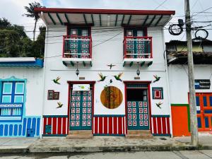 萨兰托Hostal El Quinde的白色的建筑,有色彩缤纷的门窗