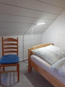 Un dormitorio con una cama, una silla y una lámpara. en Appartement Klahn Nr2, en Fehmarn
