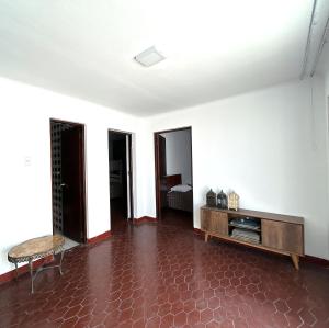 sala de estar con paredes blancas y suelo de baldosa roja. en Casa Molinera, en Lima
