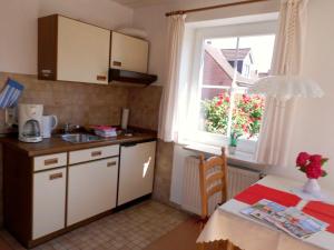 Una pequeña cocina con una mesa y una ventana. en Appartement Klahn Nr1, en Fehmarn