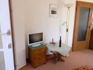 sala de estar con TV en un tocador con mesa en Appartement Klahn Nr1, en Fehmarn