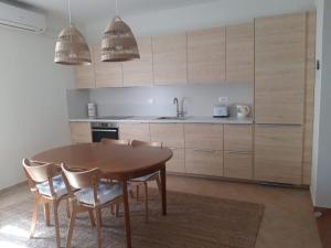a kitchen with a wooden table and chairs at Apartman Toni in Lukoran