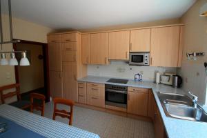 a kitchen with wooden cabinets and a sink and microwave at Ferienhof Ralf Becker Nr5 in Westfehmarn