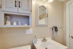 a bathroom with a white sink and a mirror at Steps to Mississippi River Hot Tub Haven! in Le Claire +20 photos