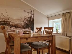 una mesa de comedor de madera con sillas y una pintura en AbendLicht, en Vadersdorf