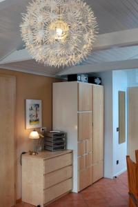 lampadario pendente appeso a un soffitto con mobile in legno di Ferienwohnung Carstensen Nr1 a Fehmarn