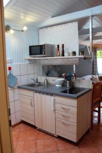 una cucina con lavello e microonde di Ferienwohnung Carstensen Nr1 a Fehmarn