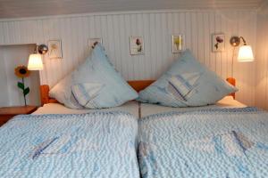 una camera con 2 letti con cuscini blu e bianchi di Ferienwohnung Carstensen Nr1 a Fehmarn Altre 6 foto