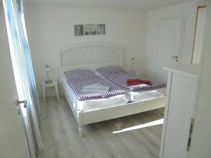 Schlafzimmer mit einem Bett mit gestreifter Decke in der Unterkunft "Ferienhaus Vadersdorf" Bungalow in Vadersdorf + 7 Fotos