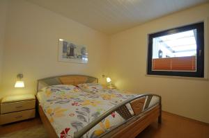 En eller flere senge i et værelse på Strandgut - Bungalow am Meer