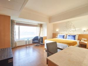 Postel nebo postele na pokoji v ubytování Sarovar Portico Rivera Ahmedabad + 37 fotografií
