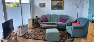 a living room with a couch and a tv at Bungalow am Südstrand Staberdorf mit Meerblick in Staberdorf