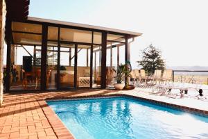 a swimming pool in front of a house at Cathedral Peak Wine Estate Manor in Winterton
