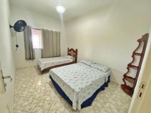 a bedroom with two beds and a window at Casa da Lu, em Santa Monica in Guarapari +24 photos