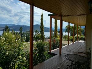a wooden deck with a table and chairs on a house at Ambience on Huon Bed & Breakfast in Cygnet