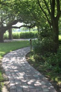 a brick path in a park with trees at Bachstelze in Neue Tiefe Fehmarn +5 photos