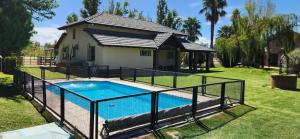a swimming pool with a fence around it in front of a house at El Sauce, casa de campo & golf in Santa Lucía