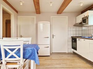 a kitchen with a white refrigerator and a table and chairs at MeerBlüte in Vadersdorf +4 photos